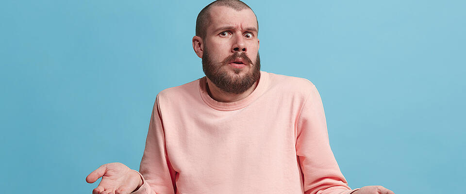 Beautiful man looking suprised and bewildered isolated on blue