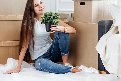 young woman dreams of sitting on the floor in a new apartment